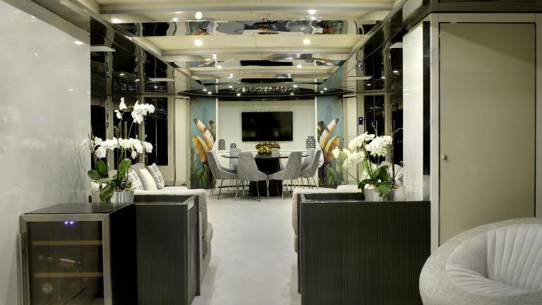 The interior of the Vetro is modernly furnished with a round glass table, minibar, sitting area and orchids .